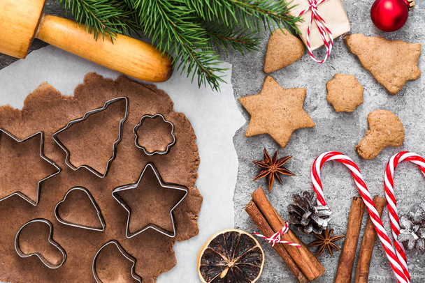 Cooking Christmas gingerbread cookies with fir tree branches and decorations on gray concrete background. top view - Photo, Image