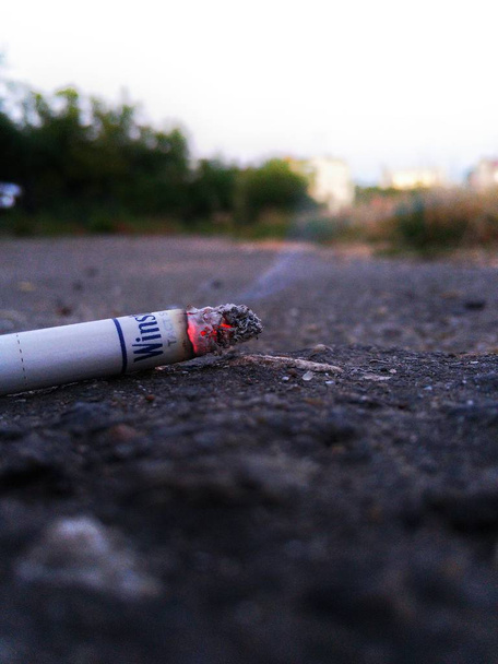smoking cigarette on the ground - Foto, afbeelding
