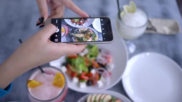 блог, мобильный телефон в женской руке женщина фотографировать здоровый вегетарианский салат во время бранча для социальных сетей, закрыть
 - Кадры, видео