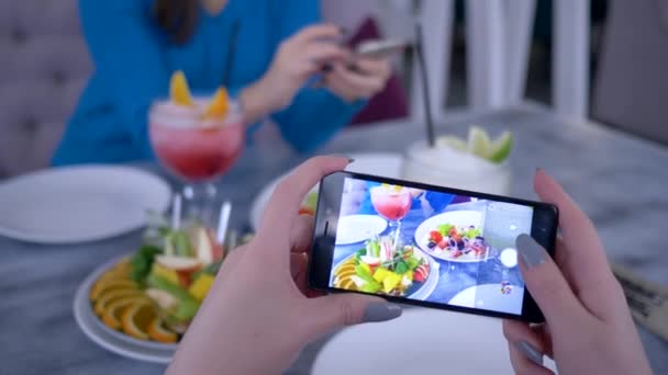 сучасні технології в дії, мобільний телефон в руці дівчини фотографує здорову вегетаріанську їжу під час обіду для соціальних мереж, крупним планом
 - Кадри, відео