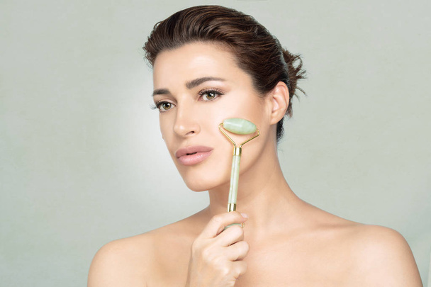 Woman using jade roller on her flawless skin. Facial treatments  - Foto, Imagem