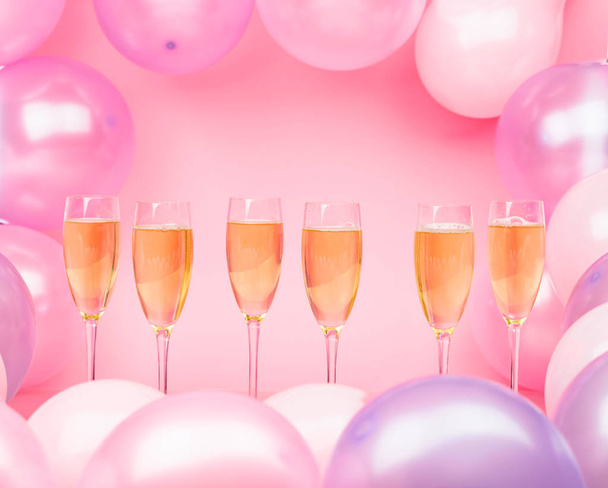 Bicchieri di champagne su sfondo rosa con b rosa e viola
 - Foto, immagini