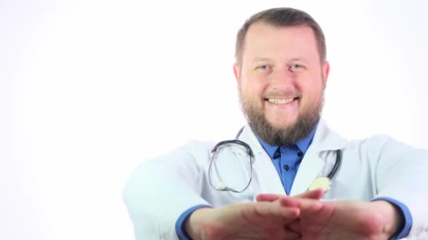 Nice chubby doctor with a beard in a white coat on a white isolated background - Video