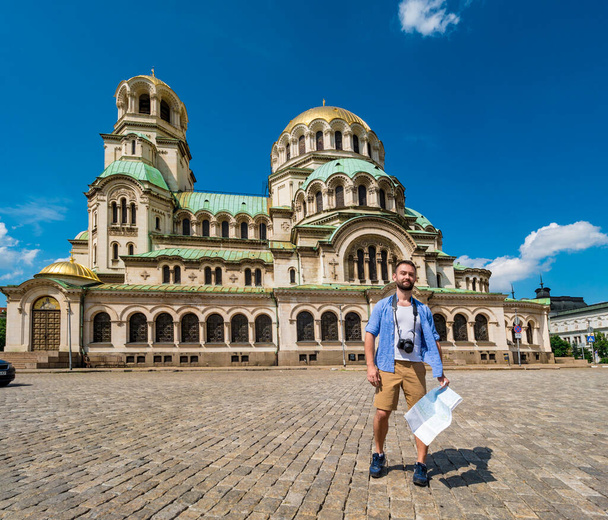 Young caucasian man takes pictures to Alexander Nevsky cathedral in Sofia, Bulgaria. Solo traveler concept. - Foto, immagini
