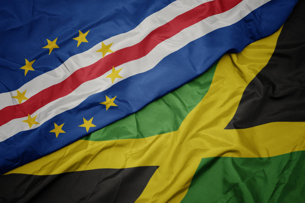 хвилястий барвистий прапор Ямайки і національний прапор мису Верде
. - Фото, зображення