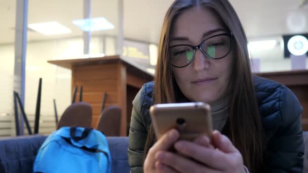žena chatuje s přáteli pomocí smartphonu a úsměvy - Záběry, video