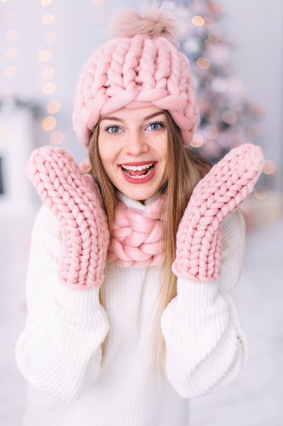 portrait of a girl with freckles in pink hat, scarf and gloves.  - 写真・画像