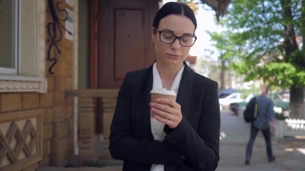 pensive young business woman walks on city streets and drinking coffee - Metraje, vídeo