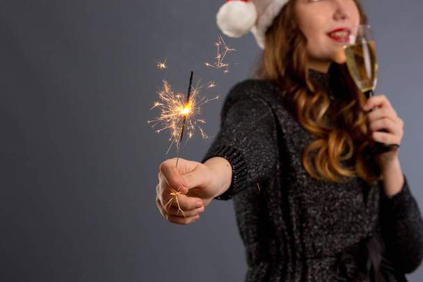 Приваблива весела дівчина з кучерявим волоссям у різдвяному капелюсі Смілін
 - Фото, зображення