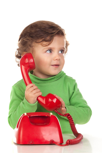 Ребенок с годовалым ребенком играл с красным телефоном
 - Фото, изображение