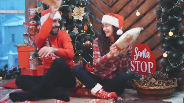 Full-body video of lively adults having fun, playing pillows fight on Christmas Eve. - Séquence, vidéo