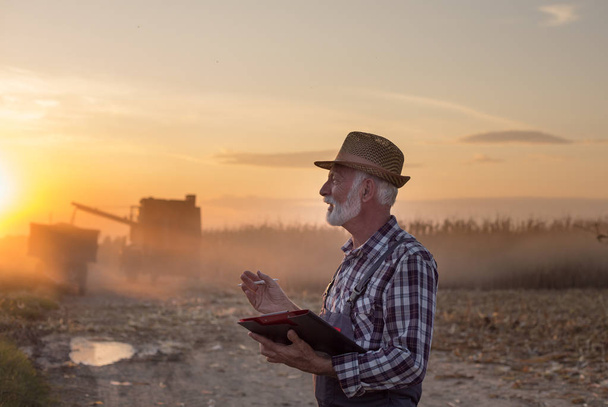 Farmer in front of combine harvester - Valokuva, kuva