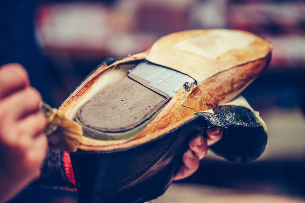 Tecrübeli bir ayakkabıcının elleri tutkal sürüyor. - Fotoğraf, Görsel