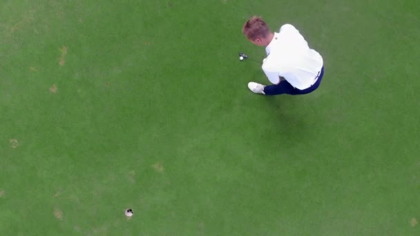 Jogador de golfe está faltando o buraco enquanto golpeia
 - Filmagem, Vídeo