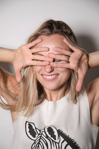 Young model laughing, covering her face with her hands. - Photo, Image