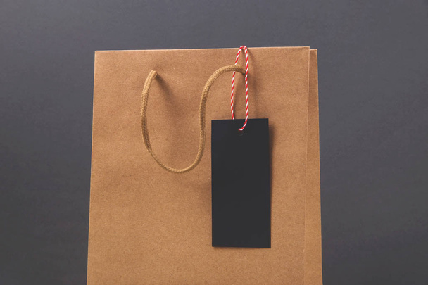 Parlak koyu arkaplanda siyah cuma günü satın alma etiketi olan Kraft kağıt çantası. - Fotoğraf, Görsel