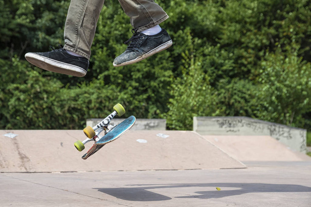 close up of boy making trick on skateboard  - Фото, изображение