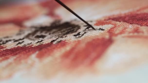 Woman hands doing cross-stitch of red flower. A close up of embroidery. - Video, Çekim