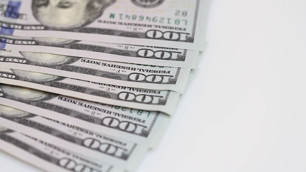 Honderd dollarbiljetten spinnen op een tafel. Close-up. Rotatie papiergeld close-up. Achtergrond met geld Amerikaanse 100-dollarbiljetten - Video