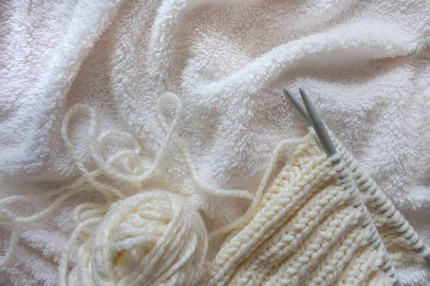 knitting white wool yarn pattern. Closeup horizontal photo. Freelance creative handicraft concept, hobby and lifestyle - Foto, imagen