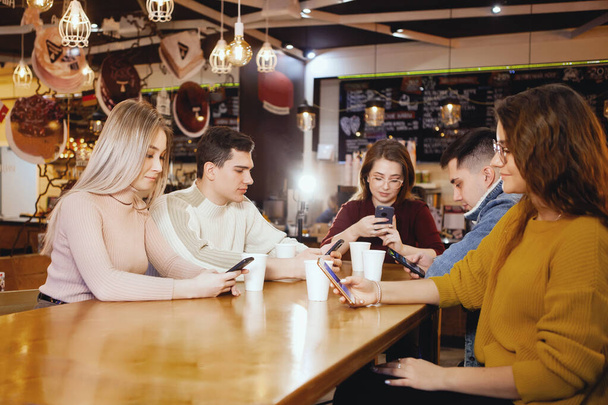 Cinque giovani studenti belli seduti in un caffè
. - Foto, immagini
