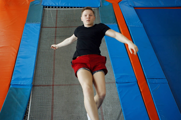Jonge man springen op een trampoline. - Foto, afbeelding
