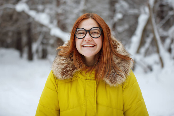 Joululoma. Kaunis hymyilevä nainen lämpimissä vaatteissa kupin kuumaa kahvia ulkona talvella
 - Valokuva, kuva