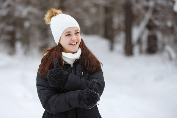Young, pretty, cheerful long-haired woman outdoor in winter. - Фото, изображение
