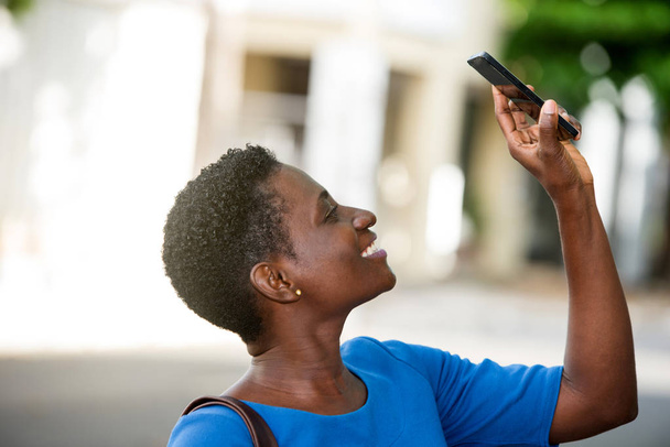 close-up van Afrikaans meisje met mobiele telefoon, gelukkig. - Foto, afbeelding