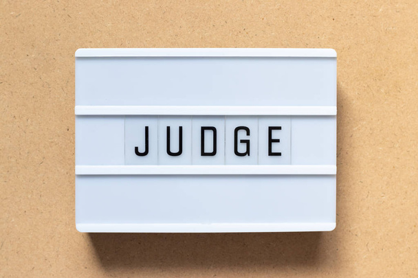Caja de luz blanca con juez de palabras sobre fondo de madera
 - Foto, Imagen