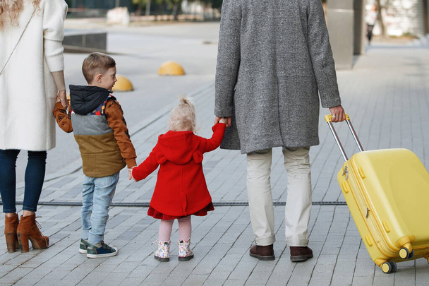 Family with yellow suitcase - 写真・画像
