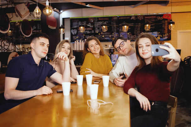 Cinco jóvenes estudiantes guapos sentados en un café
. - Foto, Imagen