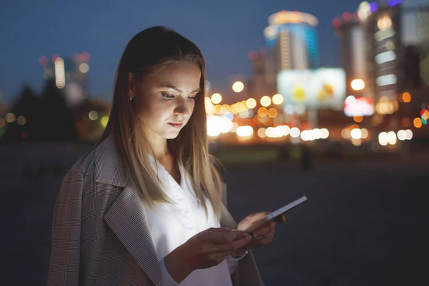 Hermosa mujer con tableta afuera en la ciudad de la noche
 - Foto, Imagen
