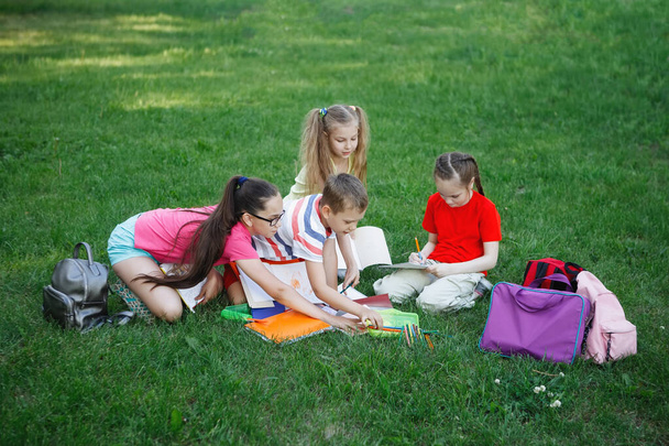 Cuatro niños sentados en la hierba verde
. - Foto, Imagen