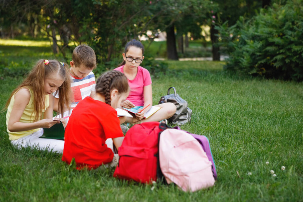 Quatro crianças sentadas na grama verde
. - Foto, Imagem