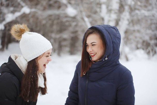 Two young, pretty women in a snowy forest. - Photo, Image