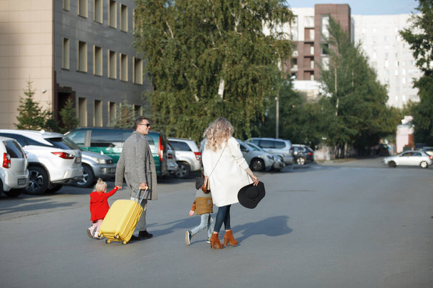 Family with yellow suitcase - Fotoğraf, Görsel