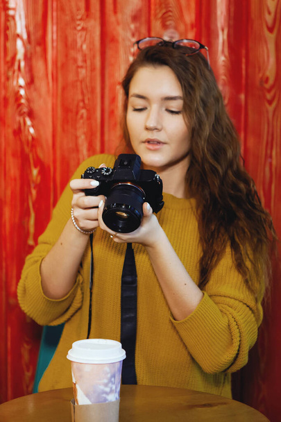 カフェでデジタルカメラを使った美しい若い女性. - 写真・画像