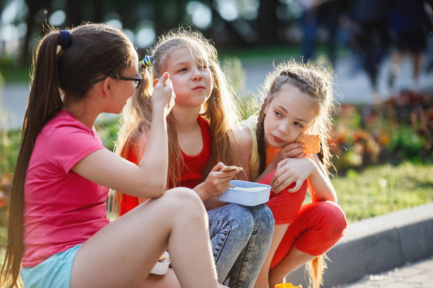 Adolescents assis sur le trottoir dans le parc de la ville
. - Photo, image