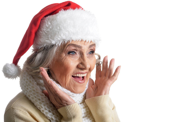 Portrait of smiling happy senior woman in Santa hat posing isolated on white background  - Fotó, kép