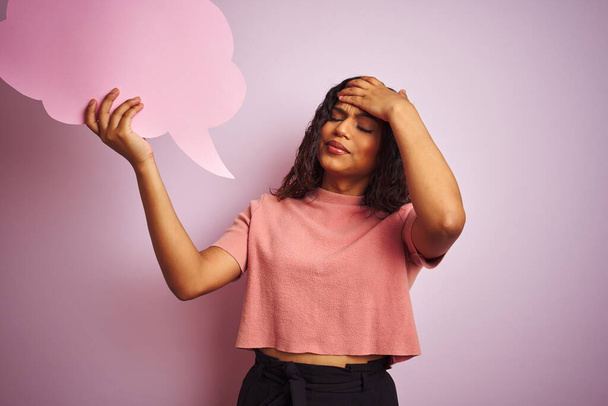 Transseksuele transgender vrouw die spraak wolk bubbel over geïsoleerde roze achtergrond gestrest met de hand op het hoofd, geschokt met schaamte en verrassing gezicht, boos en gefrustreerd. Angst en overstuur voor fouten. - Foto, afbeelding