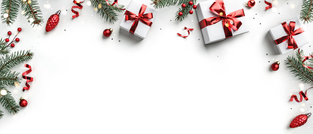 Marco creativo hecho de ramas de abeto de Navidad, cajas de regalo, decoración roja, destellos y confeti sobre fondo blanco. Navidad y Año Nuevo vacaciones, bokeh, luz. Piso tendido, vista superior - Foto, Imagen