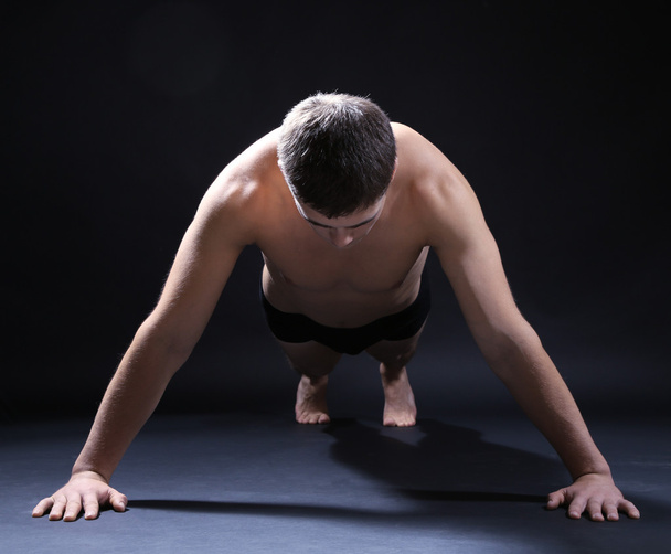 Guapo joven deportista muscular, sobre fondo oscuro
 - Foto, Imagen
