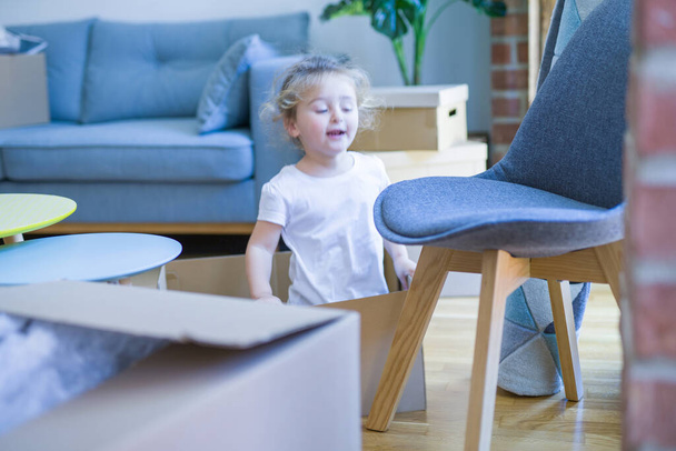 Menina criança bonita brincando com caixas em nova casa
 - Foto, Imagem