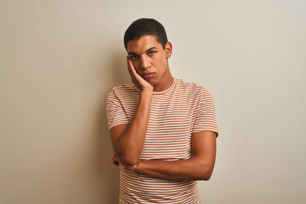 Young handsome arab man wearing striped t-shirt over isolated white background thinking looking tired and bored with depression problems with crossed arms. - Foto, afbeelding