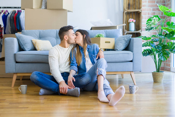 Joven hermosa pareja sentada en el piso de nuevo apartamento, sm
 - Foto, Imagen