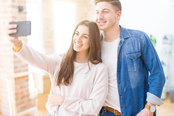 Bela jovem casal sorrindo feliz tirar uma foto selfie com
  - Foto, Imagem