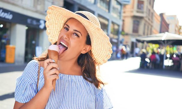 Fiatal gyönyörű nő eszik fagylaltot kúp sétál végig az utcán Tenerife egy napsütéses nyári napon ünnepnapokon - Fotó, kép