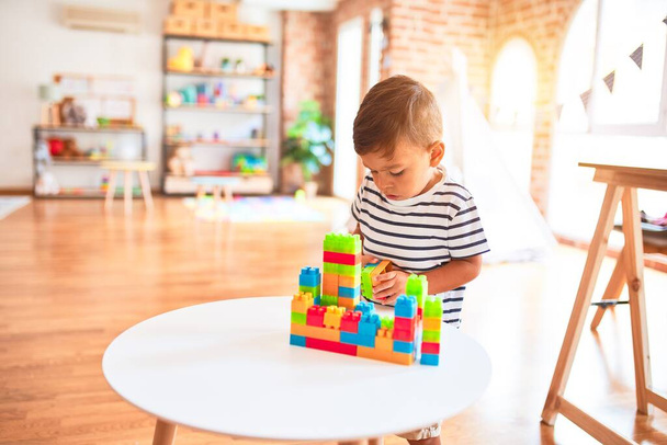 Menino da criança bonita brincando com blocos de construção no jardim de infância
 - Foto, Imagem