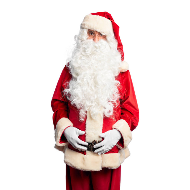 Homem bonito de meia idade vestindo traje de Papai Noel e barba de pé cético e nervoso, franzindo a testa chateado por causa do problema. Pessoa negativa
. - Foto, Imagem